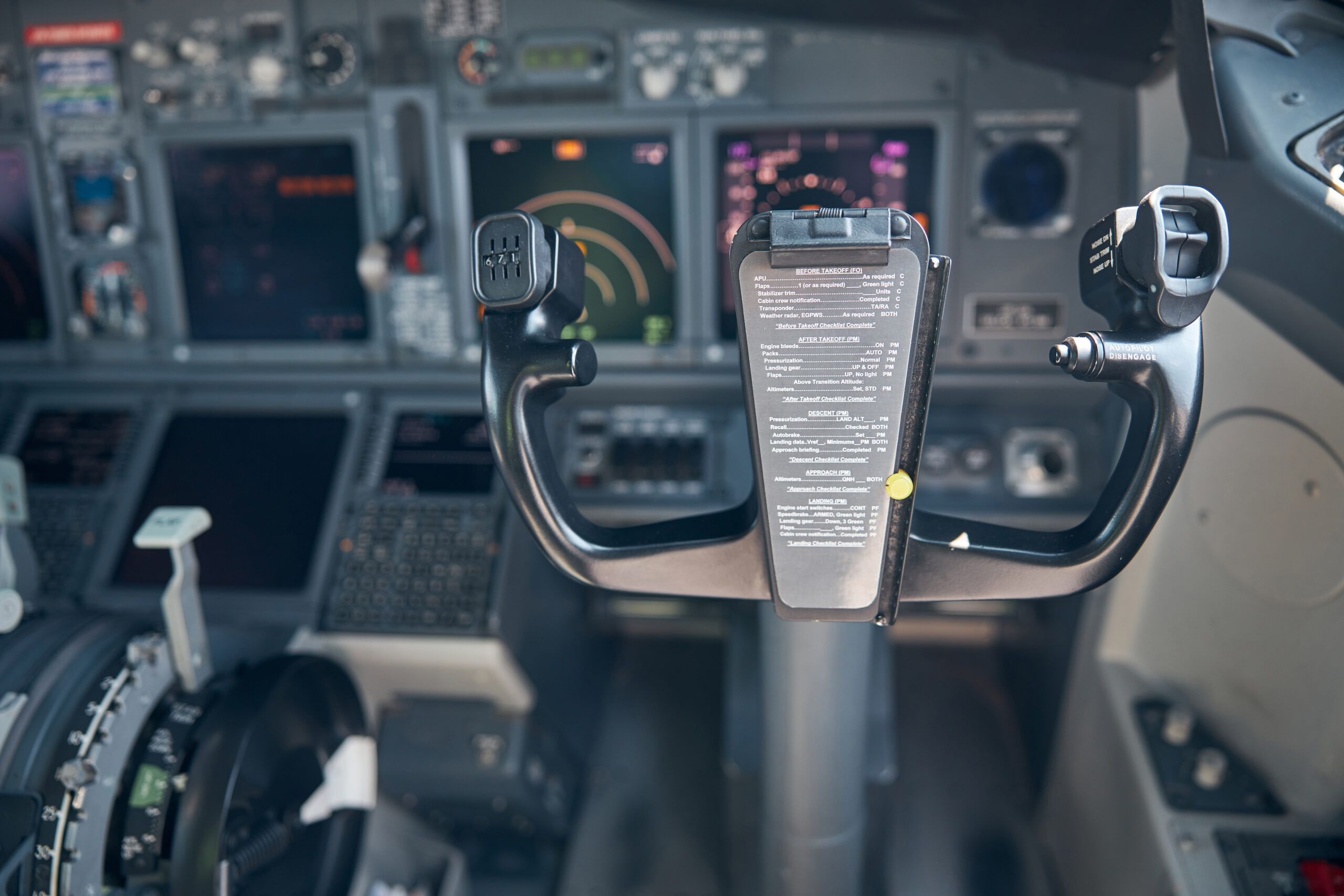 Aircraft flight deck with yoke or control wheel and instrument panel on blurred background